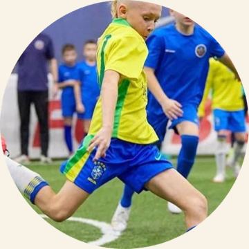 A child practising dribbling at football training