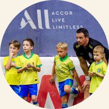 Children with their coach on the football pitch