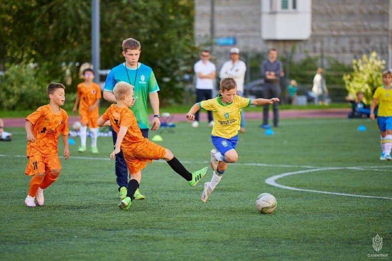 Momento de jogo no torneio «Taça de César»: jovem futebolista da academia leva a bola contra um adversário